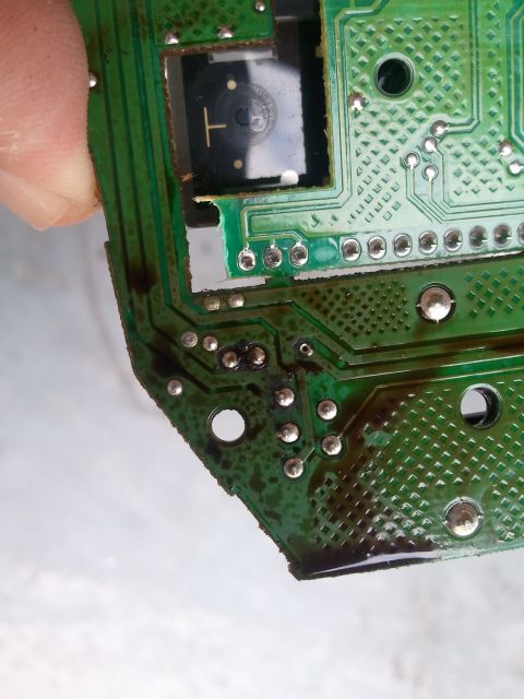 1994 Ford Bronco - Close-up of a damaged circuit board, showing burnt components and a small sensor.
