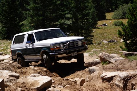 1996 Ford Bronco - This 1996 Ford Bronco is tackling a challenging off-road course with large rocks and dirt.