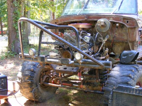 1978 Ford Bronco - This heavily modified off-road vehicle features a custom bumper, exposed engine, and oversized tires, suggesting it's built for terrain.