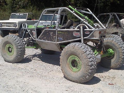 1989 Ford Bronco - A custom buggy and a classic 1969 Ford Bronco are parked together on a gravel surface.