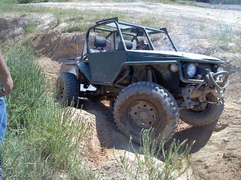1989 Ford Bronco - This custom buggy is navigating a steep, sandy incline on an off-road trail.