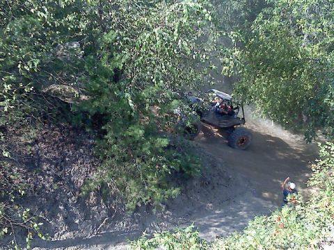 1989 Ford Bronco - An off-road buggy kicks up dust as it maneuvers along a wooded trail.