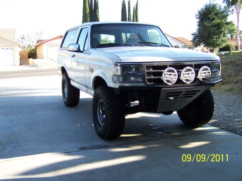1995 Ford Bronco - This modified Ford Bronco sits on a driveway, its off-road upgrades and custom front bumper.
