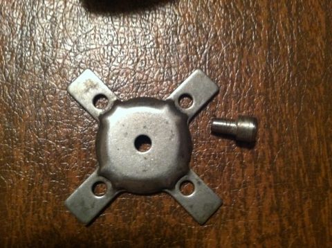 1981 Garelli Rally Sport - A metal bracket and a screw are shown on a wooden surface.