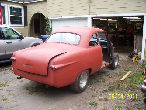 1990 Ford Bronco - A classic red coupe, likely from the 1950s, sits in a driveway with its doors removed for restoration.