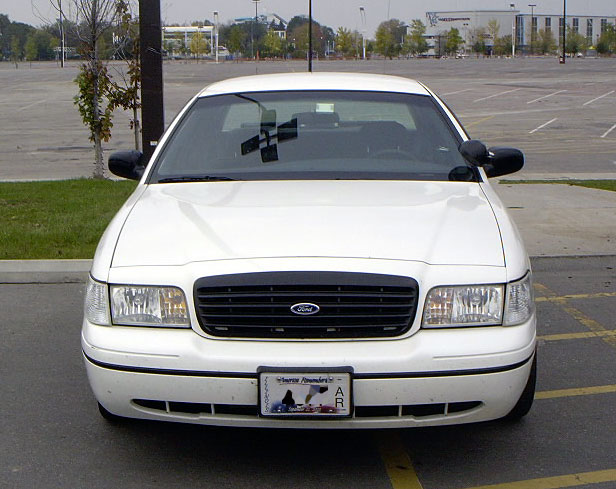 Front view of a white 1999 Ford Crown Victoria parked in an empty lot