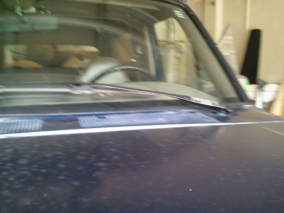 View of a dark blue Ford Bronco interior from the hood, showing the windshield, dashboard, and steering wheel