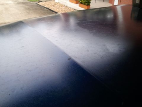 1994 Ford Bronco - The car hood shows a distinct line where one section is more reflective than the other.