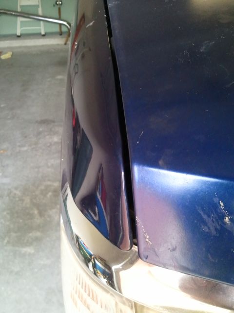 1994 Ford Bronco - The gap between the hood and fender of a blue vehicle is visible in this close-up shot.