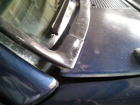 1994 Ford Bronco - Close-up of a vehicle's hood and windshield wiper assembly, showing wear and tear.