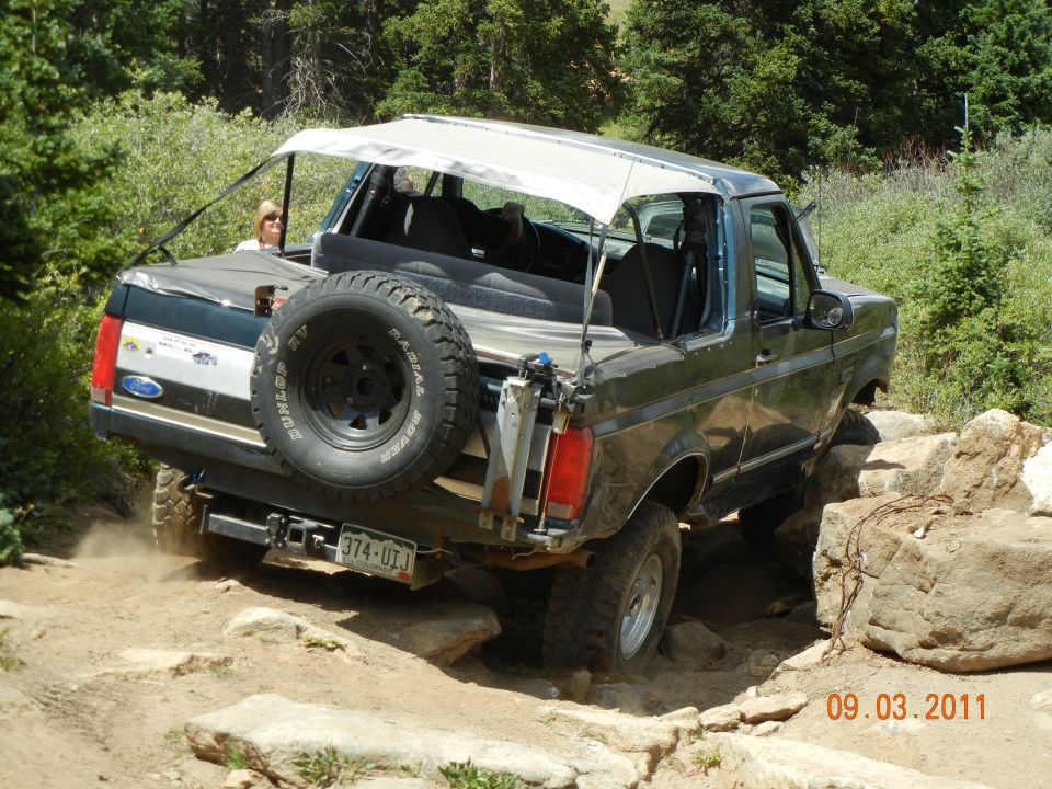 1996 Ford Bronco rear view, off-roading on rocks with spare tire mounted