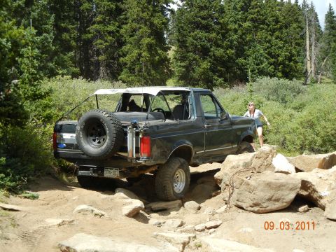 1996 Ford Bronco - A 1996 Ford Bronco tackles a challenging off-road course on a sunny day.