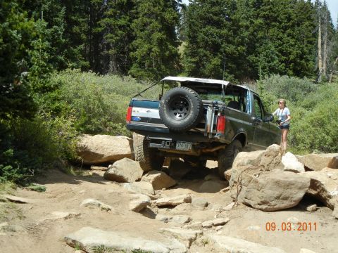 1996 Ford Bronco - A Ford Bronco tackles a challenging off-road course with large rocks.