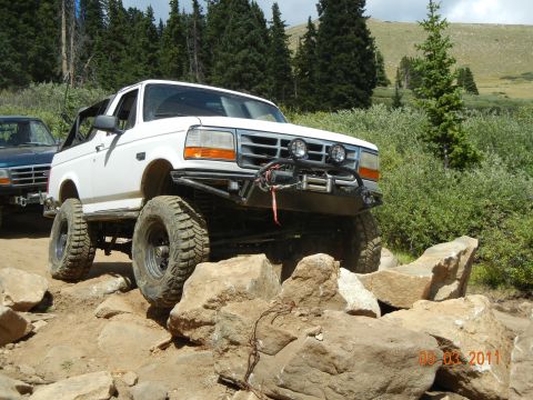 1996 Ford Bronco - 1996 Ford Bronco tackling a challenging rocky trail in a mountainous landscape.