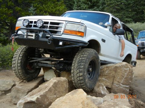 1996 Ford Bronco - White 1996 Ford Bronco tackles a rocky trail with a second vehicle in the background.