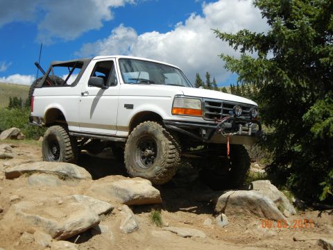 1996 Ford Bronco - This 1996 Ford Bronco is equipped for extreme off-roading, tackling a challenging rocky trail with its lifted suspension and large tires.