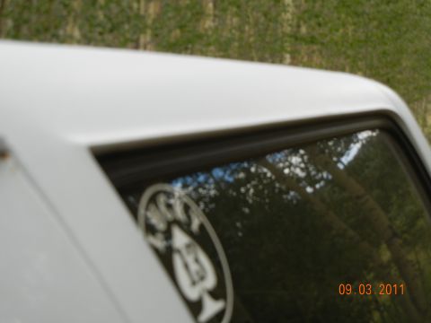 1996 Ford Bronco - White SUV roof and window detail with a sticker and date overlay.