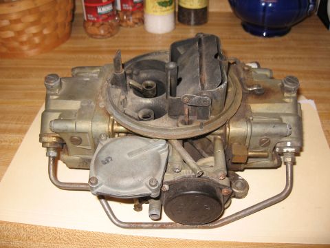 1968 Shelby GT500 - A vintage Holley carburetor is shown on a table, with a watermark indicating it's from Supermotors.net.