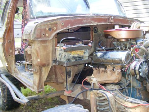 1978 Ford Bronco - The engine bay of a Ford Bronco shows the battery and engine components, with some wear and tear.
