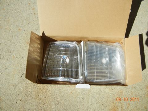 1996 Ford Bronco - Two clear plastic car headlights are shown in a cardboard box, with a date stamp of 09.10.2011 visible.