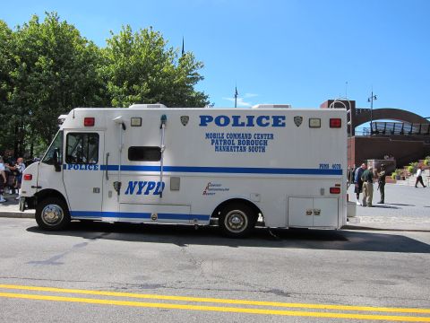 1991 Ford LTD Crown Victoria - white NYPD Police Mobile Command Center truck for Patrol Borough Manhattan South is parked on a sunny city street.