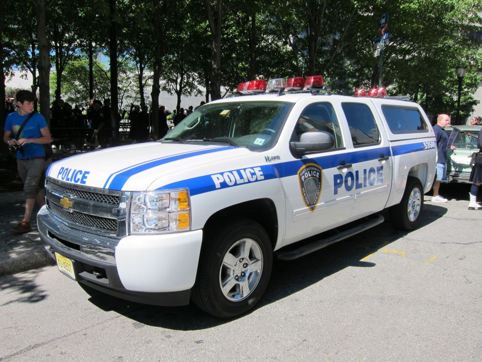 White and blue Chevrolet police crew-cab pickup with light bar