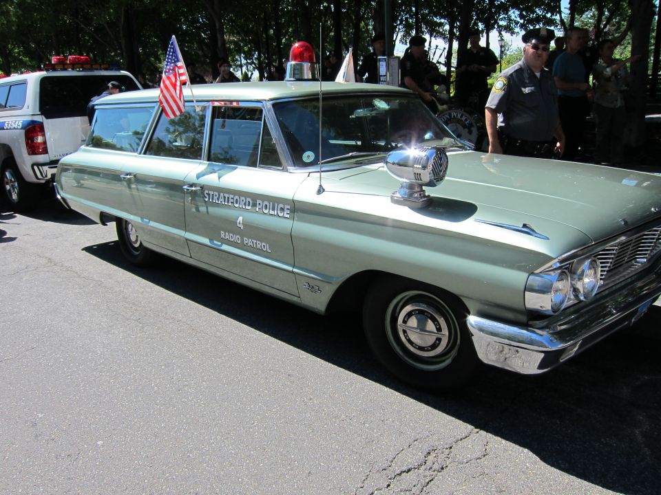 Vintage green Stratford Police station wagon with US flag