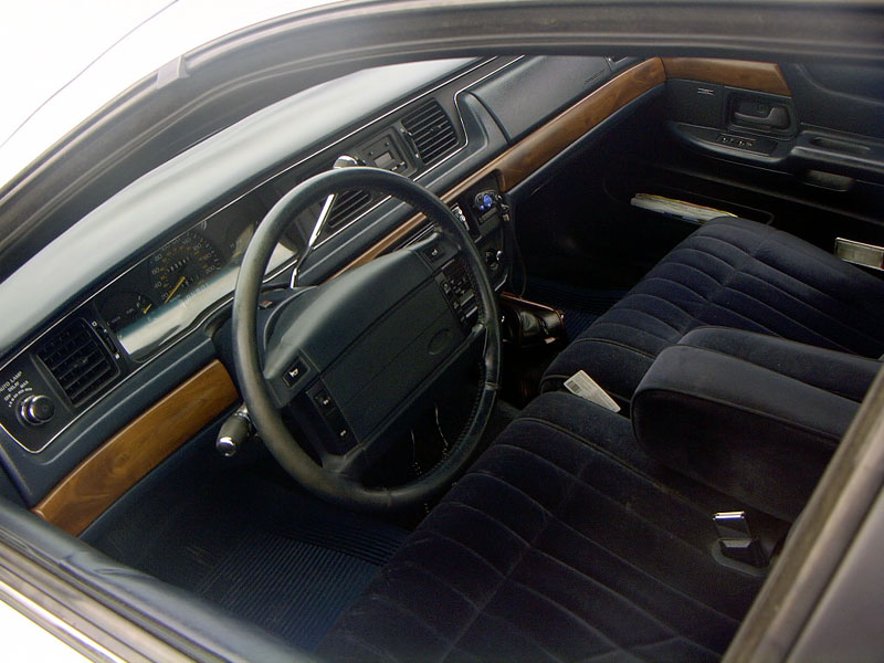 1999 Ford Crown Victoria interior with blue velour seats and wood trim dashboard