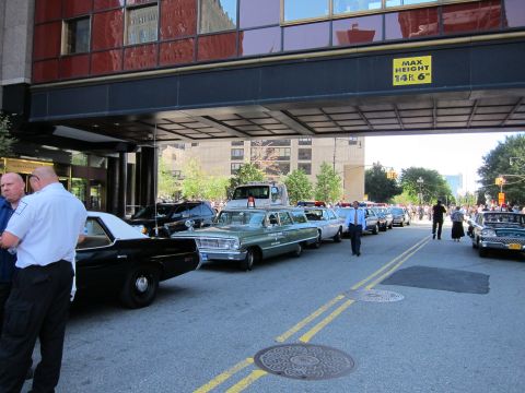 1991 Ford LTD Crown Victoria - line of vintage police station wagons and sedans sits under a building overpass sign reading Max Height 14 ft 6 in.