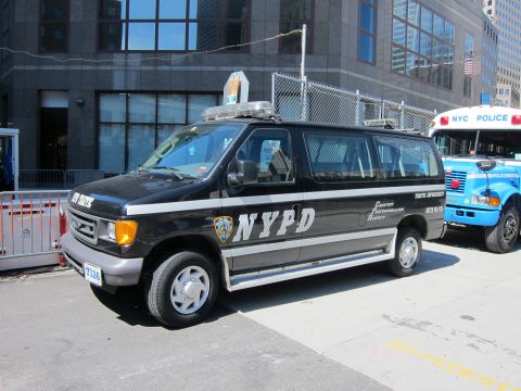 1991 Ford LTD Crown Victoria - black Ford NYPD Traffic Enforcement van sits at the curb with a blue NYC Police bus visible behind it.