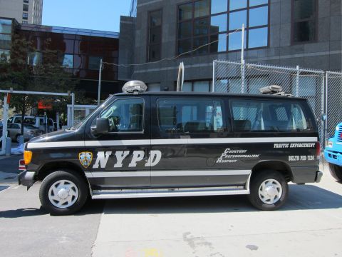 1991 Ford LTD Crown Victoria - driver side of a black NYPD Traffic Enforcement van shows the department shield and Courtesy Professionalism Respect lettering.