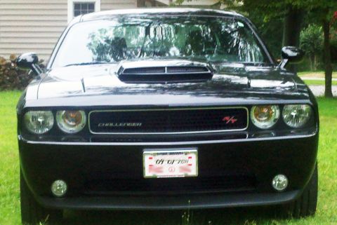 2011 Dodge Challenger - A black Dodge Challenger is parked on a grassy lawn in front of a house.