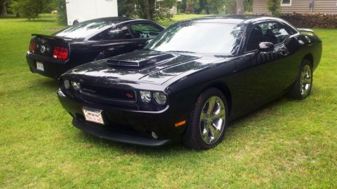 2011 Dodge Challenger - A black Dodge Challenger is parked on the grass, with a black Ford Mustang behind it.
