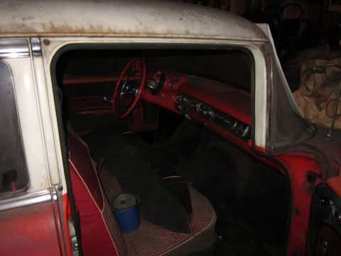 1991 Ford LTD Crown Victoria - The interior of a vintage automobile shows a red dashboard and seats, with a spool of thread on the passenger seat.