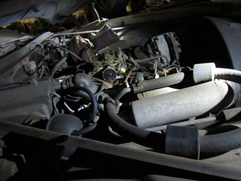 1991 Ford LTD Crown Victoria - A cluttered engine bay with various components and hoses.