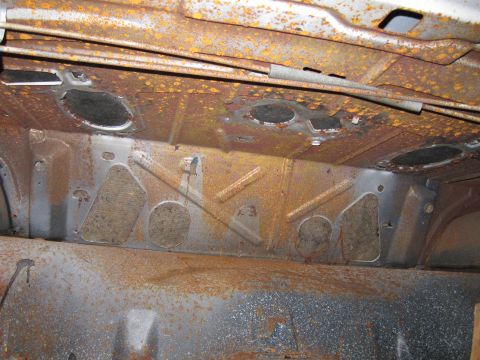 1991 Ford LTD Crown Victoria - The underside of a vehicle displays extensive rust damage and structural components.