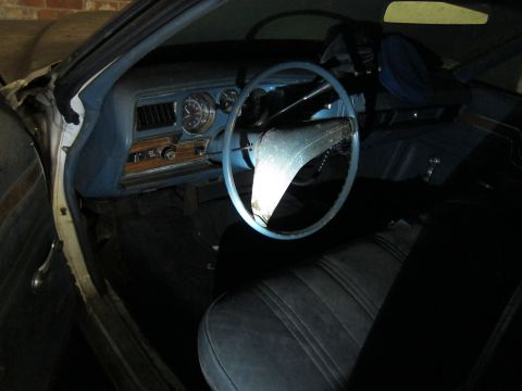 1991 Ford LTD Crown Victoria - The interior of a classic car shows a blue dashboard, steering wheel, and seats, with visible wood grain trim.