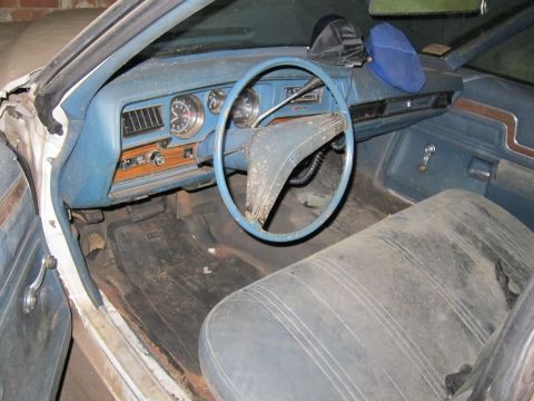 1991 Ford LTD Crown Victoria - Dusty interior of a classic car, showing the dashboard, steering wheel, and front seats.