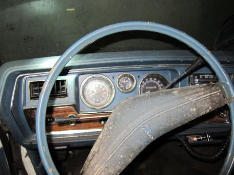 1991 Ford LTD Crown Victoria - The interior of a car shows a dusty dashboard with a prominent steering wheel and instrument cluster.