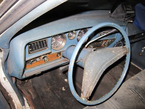 1991 Ford LTD Crown Victoria - Interior view of a dusty car's dashboard and steering wheel, showing gauges and radio.