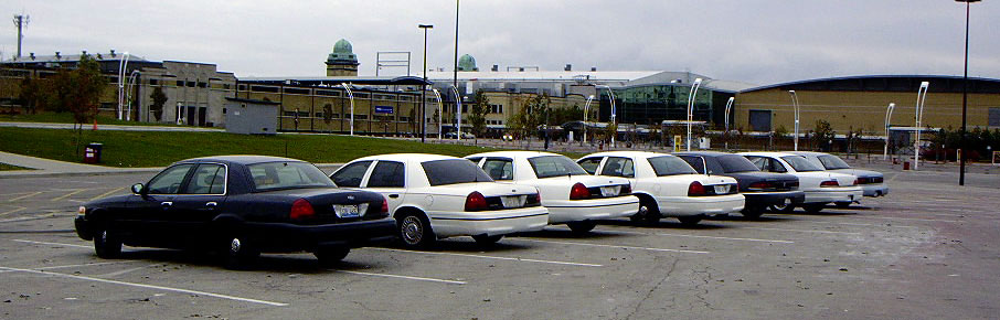 Dark blue 1999 Ford Crown Victoria parked in a row of white sedans