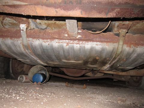 1991 Ford LTD Crown Victoria - The underside of a car, showing significant rust on the fuel tank and chassis components.