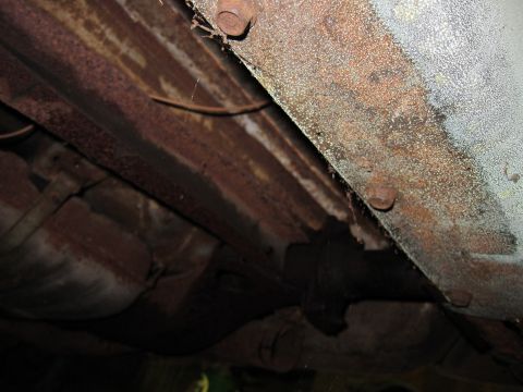 1991 Ford LTD Crown Victoria - The underside of this vehicle displays significant rust and corrosion on its structural components.