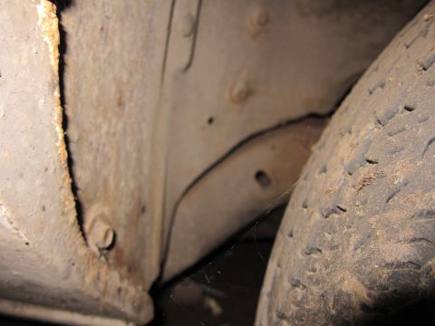 1991 Ford LTD Crown Victoria - A close-up view of a tire and the vehicle's frame, showing signs of rust and wear.