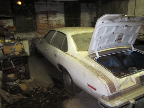 1991 Ford LTD Crown Victoria - This dusty sedan sits in a garage with its trunk open, surrounded by various items.