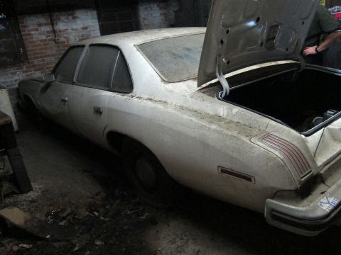 1991 Ford LTD Crown Victoria - A dusty white sedan sits with its trunk open in a dimly lit garage.