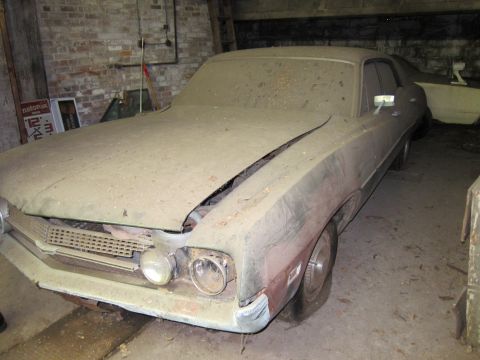 1991 Ford LTD Crown Victoria - A vintage car sits covered in dust inside a garage, with another vehicle in the background.