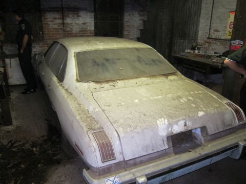 1991 Ford LTD Crown Victoria - A dusty white sedan sits in a garage, showing handprints on its trunk and rear.