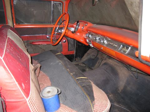 1991 Ford LTD Crown Victoria - The interior of an old car shows worn seats and an orange dashboard with chrome accents.