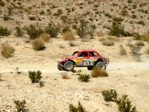 1996 Ford Bronco - A modified buggy races across a dusty desert terrain during an off-road event.